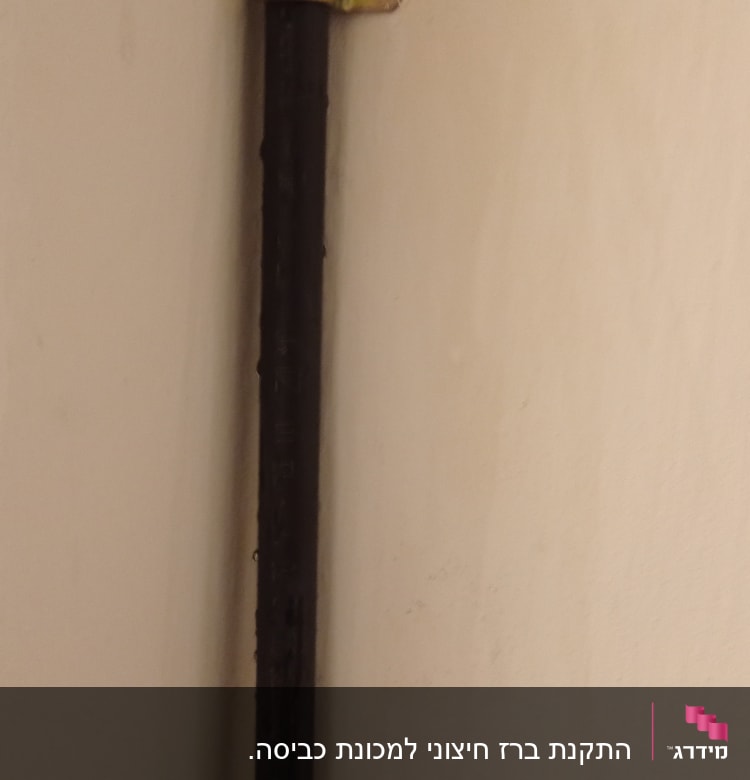 צינור שחור מחובר לקיר עם תושבת מתכת